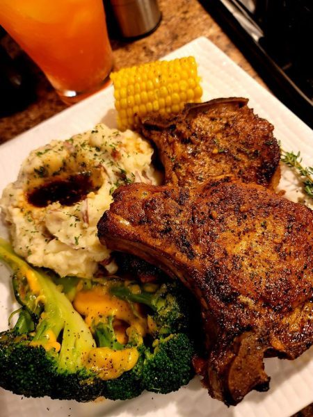"Juicy Porterhouse Pork Chops sizzling on the grill, ready to be served for a gourmet meal."