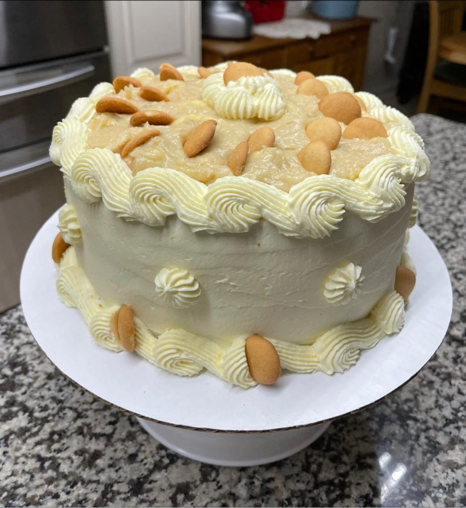 Banana Pudding Cake - Moist yellow cake layers filled with creamy banana custard and topped with whipped cream and Nilla wafers.