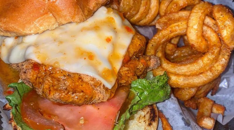 "Fried Salmon Sandwich and Curly Fries – A Perfect Blend of Crispy and Juicy Delights"
