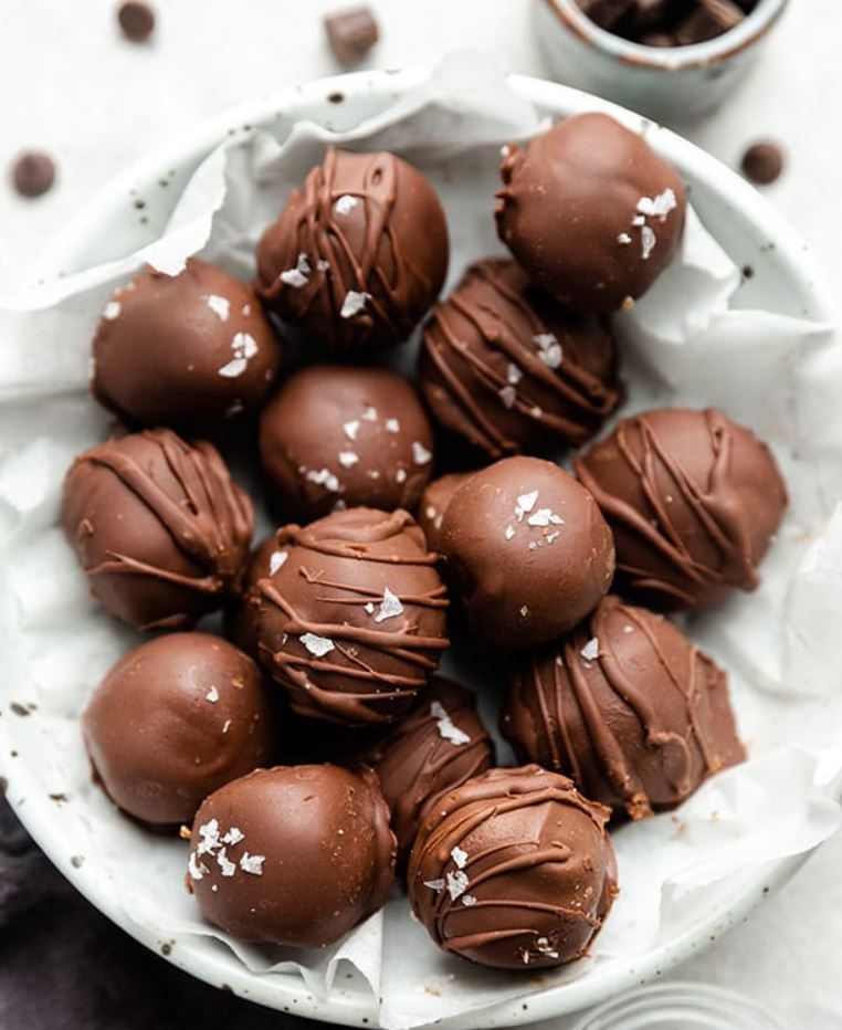 A plate of homemade chocolate truffles with a rich chocolate coating