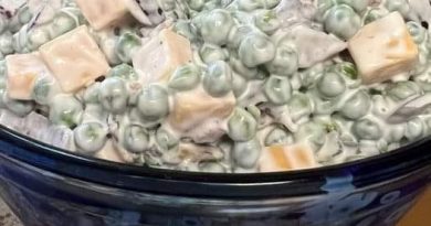Classic Pea Salad: A bowl filled with vibrant green peas, crispy bacon, diced red onion, and cubed cheddar cheese, coated in a creamy dressing.