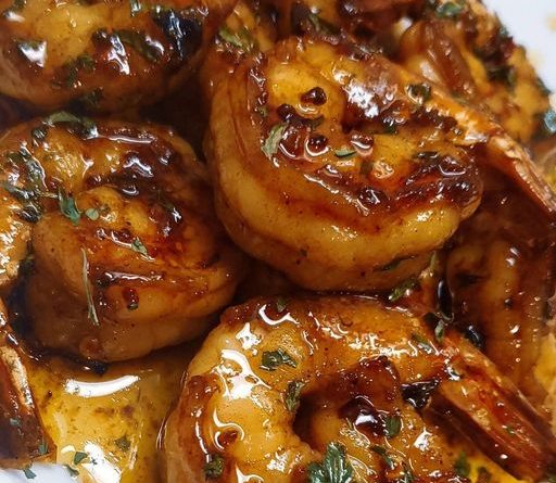 "Henny Butter Shrimp: A plate of succulent shrimp bathed in a rich Hennessy-infused sauce, garnished with fresh parsley."
