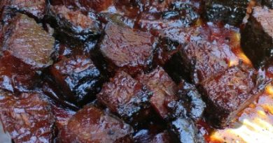 Smoked brisket burnt ends arranged on a platter, glazed to perfection.