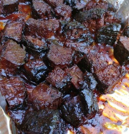 Smoked brisket burnt ends arranged on a platter, glazed to perfection.