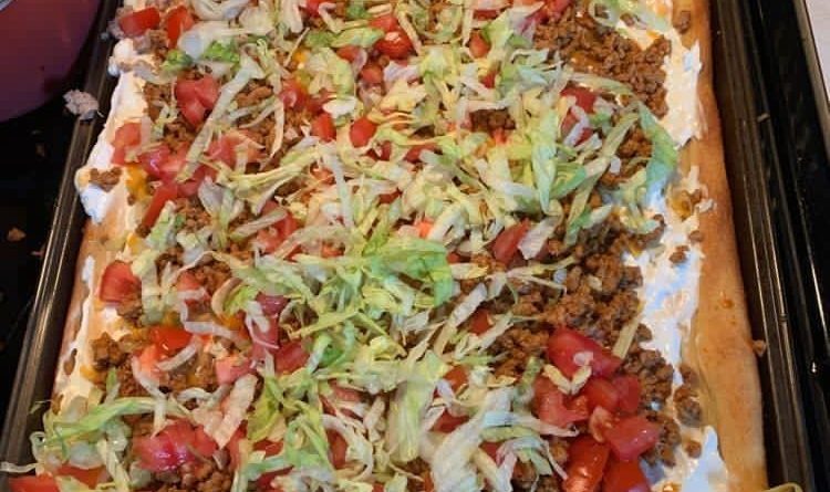 Taco Pizza - A delectable fusion of ground beef, jalapeño beans, melted cheese, and vibrant toppings on a golden-brown crust.