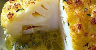 Whole Roasted Cauliflower with Butter Sauce, a golden masterpiece with thyme and bay leaves, sliced and served to perfection.