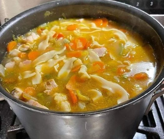 Steaming bowl of homemade chicken noodle soup - a comforting culinary delight.