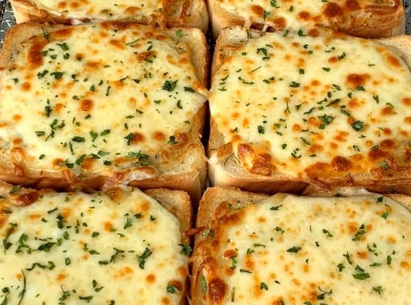 Cheesy Texas Toast with garlic-infused butter, cheddar, Monterey Jack, and Parmesan cheese, oregano, and basil, toasted to golden perfection.