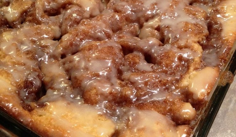 Cinna-Bun Cake displayed on a white plate, topped with a generous layer of cinnamon-infused goodness.