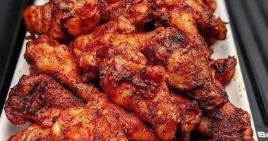 Smoked chicken wings arranged on a grill, showcasing a perfect blend of spices and a tantalizing crispy finish.