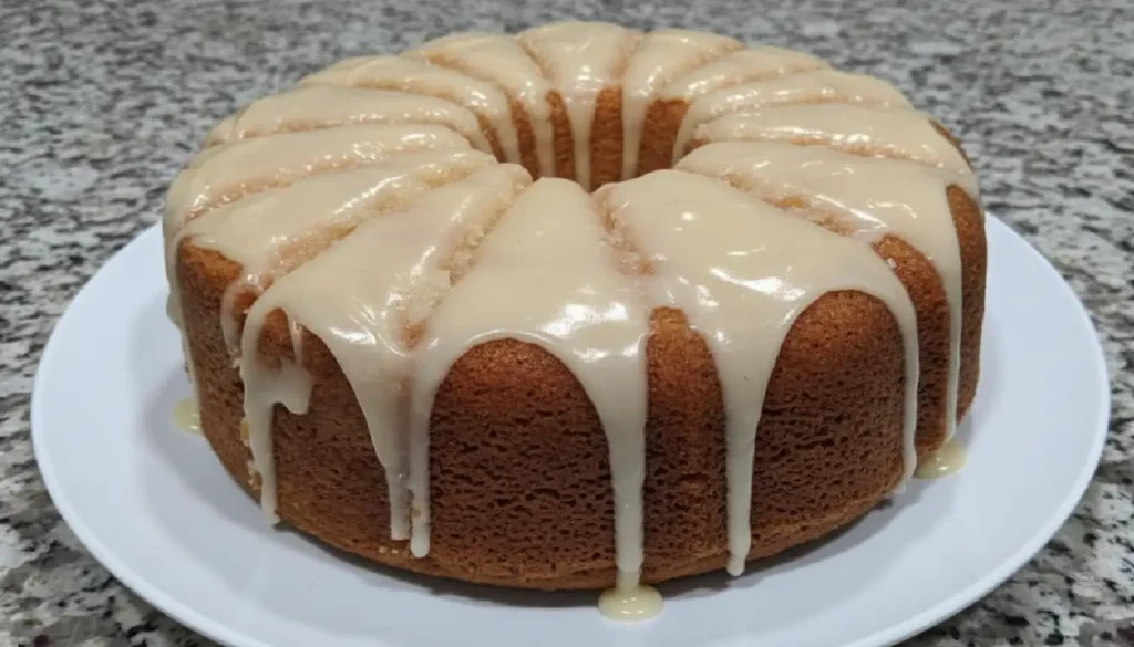 A photo of a slice of lemon cream cheese pound cake on a white plate.