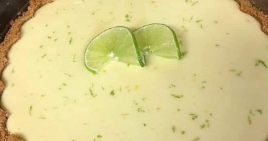 Close-up slice of key lime pie with whipped cream and lime wedge.