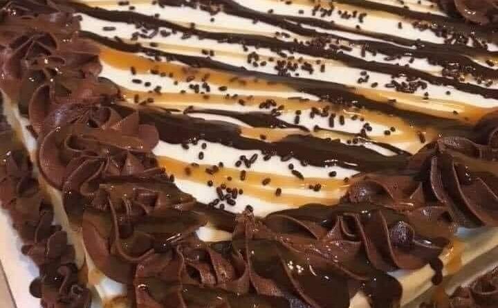 Image of a moist chocolate cake with layers of chocolate cake and caramel sauce dripping down the sides.