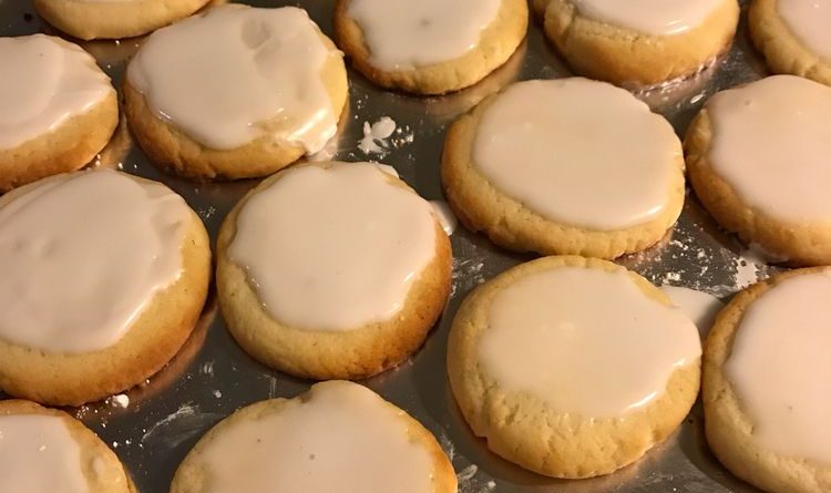 A close-up photo of almond meltaway cookies on a cooling rack. The cookies are light and airy, with a sprinkle of sliced almonds on top.