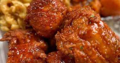 A plate with Cajun-seasoned salmon bites, creamy macaroni and cheese, and roasted yam slices.