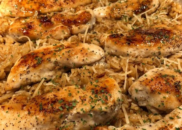 A skillet filled with tender chicken pieces and fluffy rice in a creamy garlic parmesan sauce.