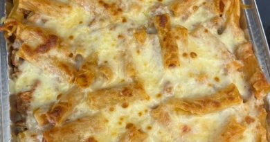 A bubbling hot baking dish filled with rigatoni pasta in a creamy tomato sauce, topped with melted mozzarella cheese and a sprinkling of fresh parsley.