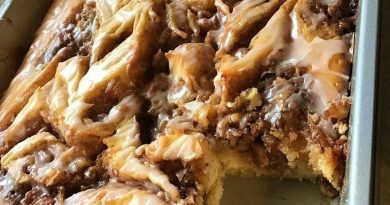 A close-up photo of a sliced Cinnabon Cinnamon Roll Cake revealing a gooey cinnamon swirl center and a creamy white glaze drizzled on top.