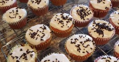 A close-up photo of a sliced Granny's Strawberry Cake with Cream Cheese Frosting. Fresh strawberries are visible throughout the cake layers.