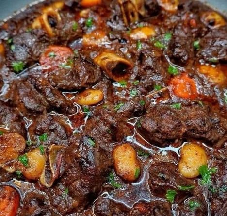 Plate of Jamaican Oxtail with rice and peas, garnished with fresh parsley