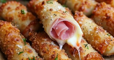 Baked ham and cheese mozzarella sticks on a plate with marinara dipping sauce