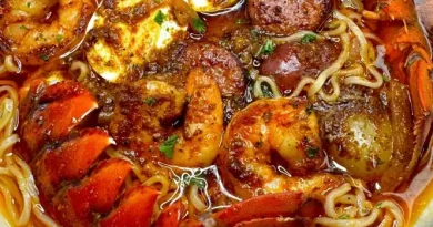 Seafood boil ramen with shrimp, crab, sausage, boiled eggs, and ramen noodles in a rich seasoned broth.
