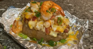 Loaded Seafood Baked Potato with Creamy Cajun Shrimp Sauce - A plate of golden-brown baked potatoes topped with succulent shrimp and a luscious Cajun-infused creamy sauce