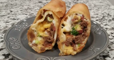 A plate of homemade beef and cheese chimichangas with toppings such as sour cream, guacamole, and salsa.